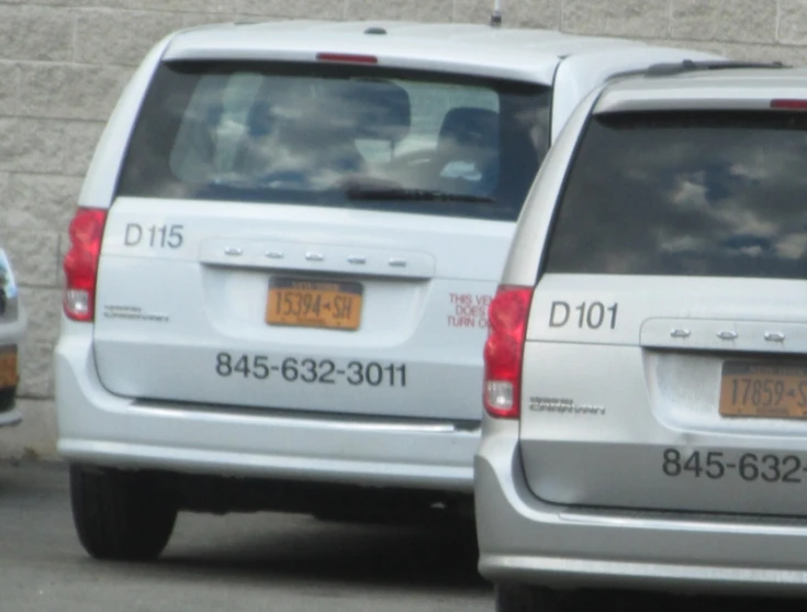 two white vans parked on the side of a street