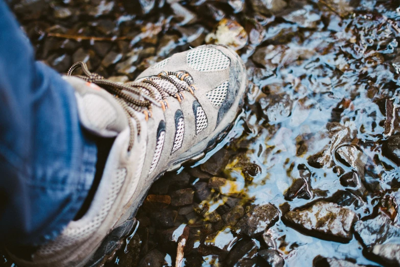 the closeup of someone's foot and shoe in the water