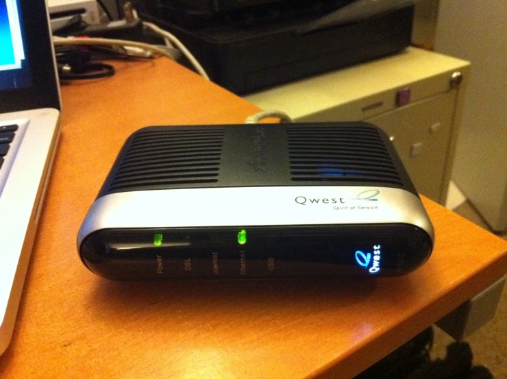 a laptop sitting on a desk next to a router