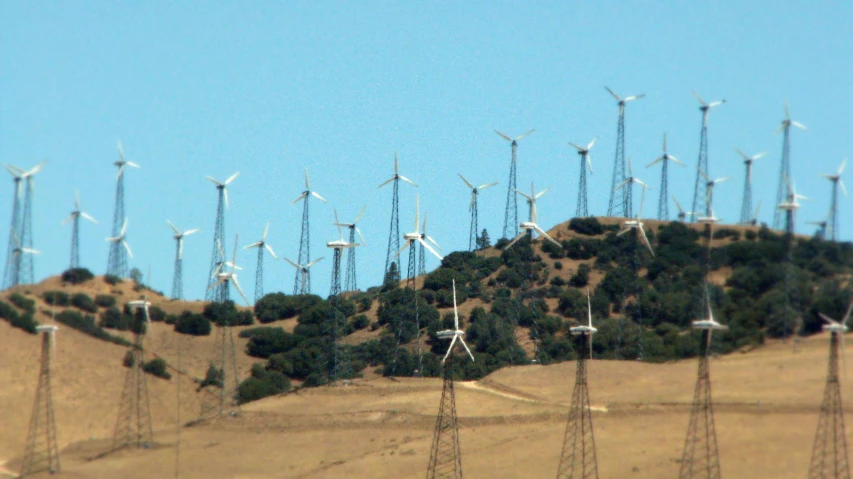 many white wind mills on top of a hill