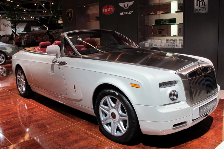 the front of a large white rolls royce parked inside of a building