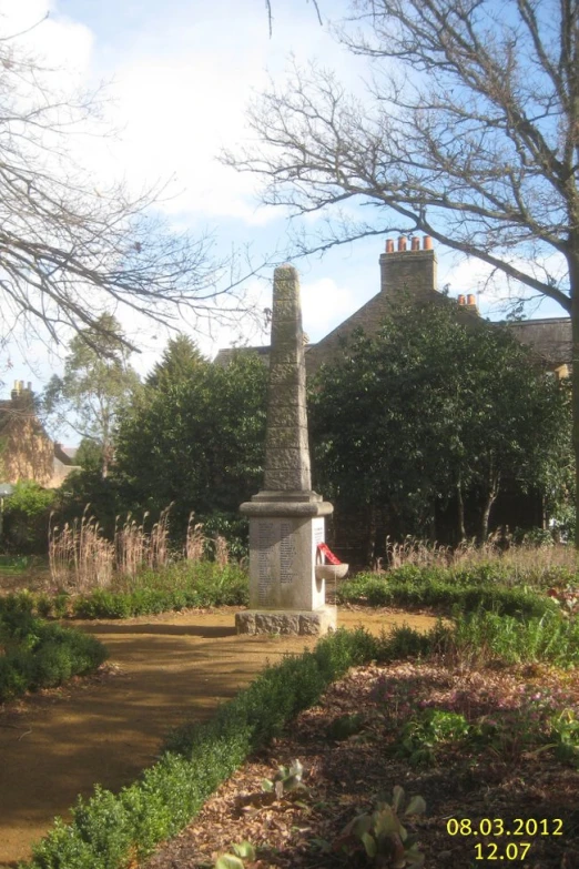 the small clock tower is next to the bushes