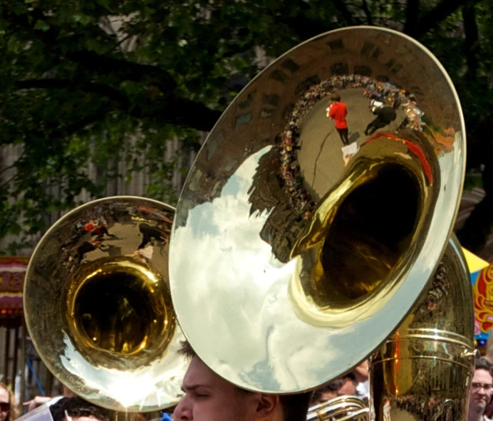 a woman standing on the sidewalk carrying an instrument in her hand