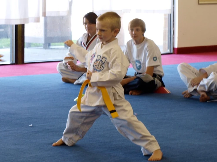 four young s are practicing karate on the floor