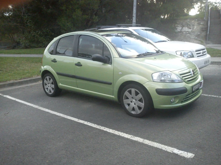 there is a small green car parked on the street