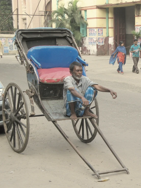 a man sits in a cart with a large bag