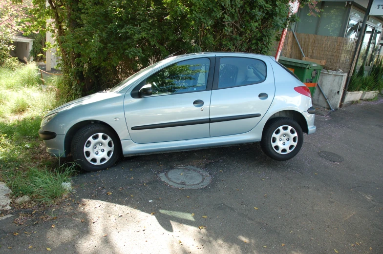 a silver small car parked on a narrow road