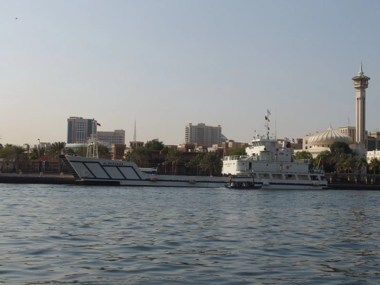 a large boat sailing down the river in front of the city