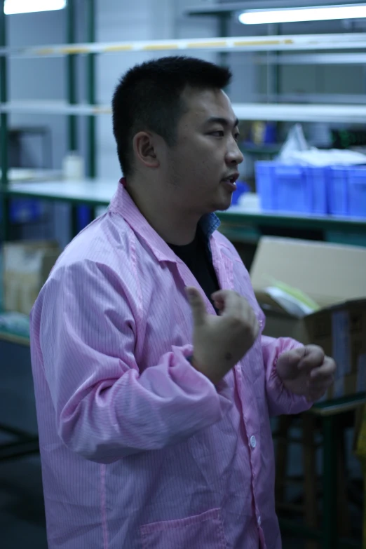 a man stands with his hands up while wearing pink striped clothing