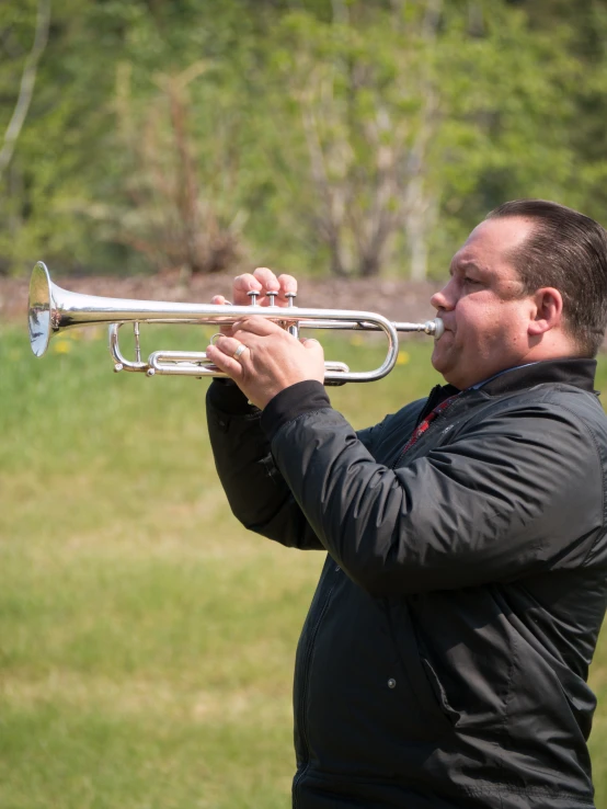 a man in a black shirt playing a trumpet