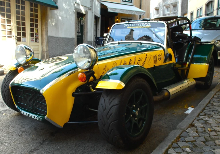 a green and yellow classic sports car parked on the side of the street
