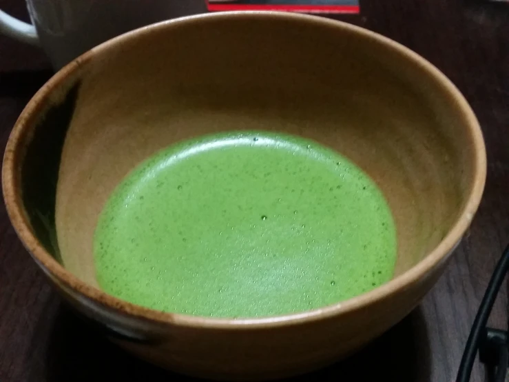 bowl of green soup sitting on the counter