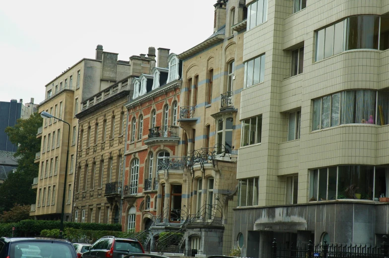 old building along side of a street with cars parked in front