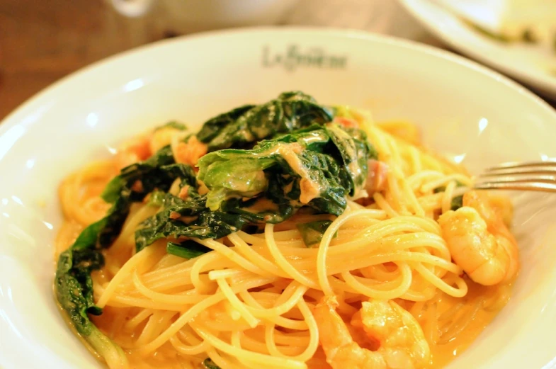 a close up of a pasta dish on a plate with a fork