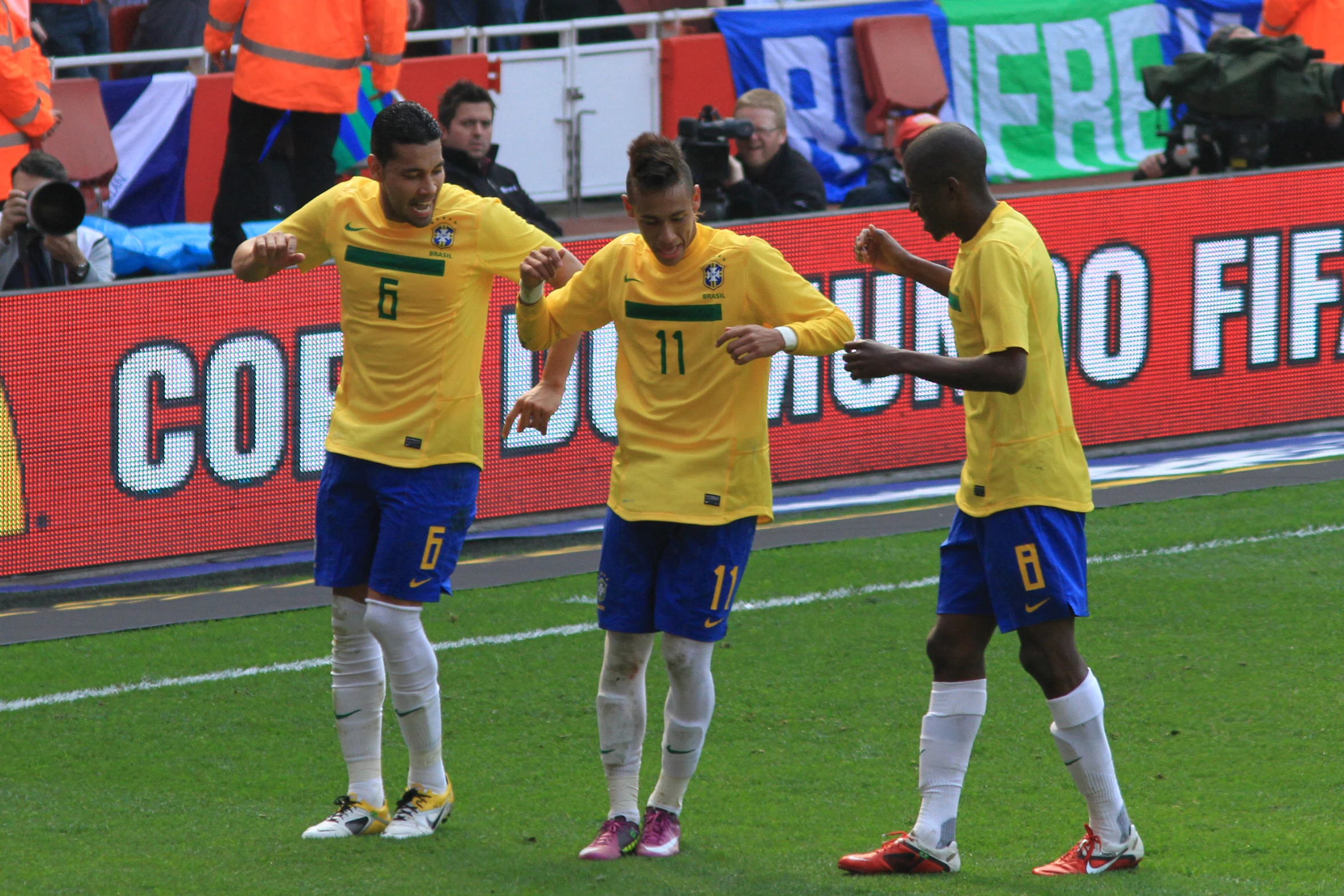 three soccer players celete with arms around each other