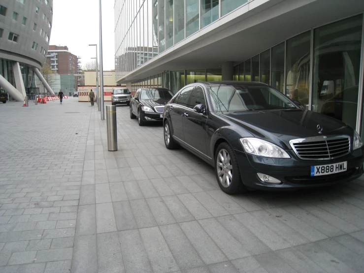 a bunch of cars parked in front of glass buildings