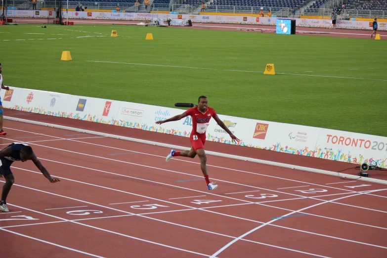 a male athlete running on a track with spectators watching