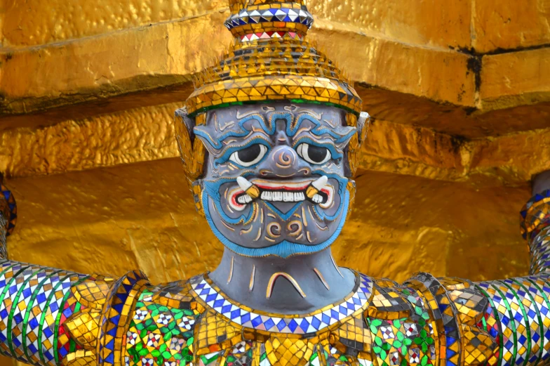 a colorfully painted statue with gold background