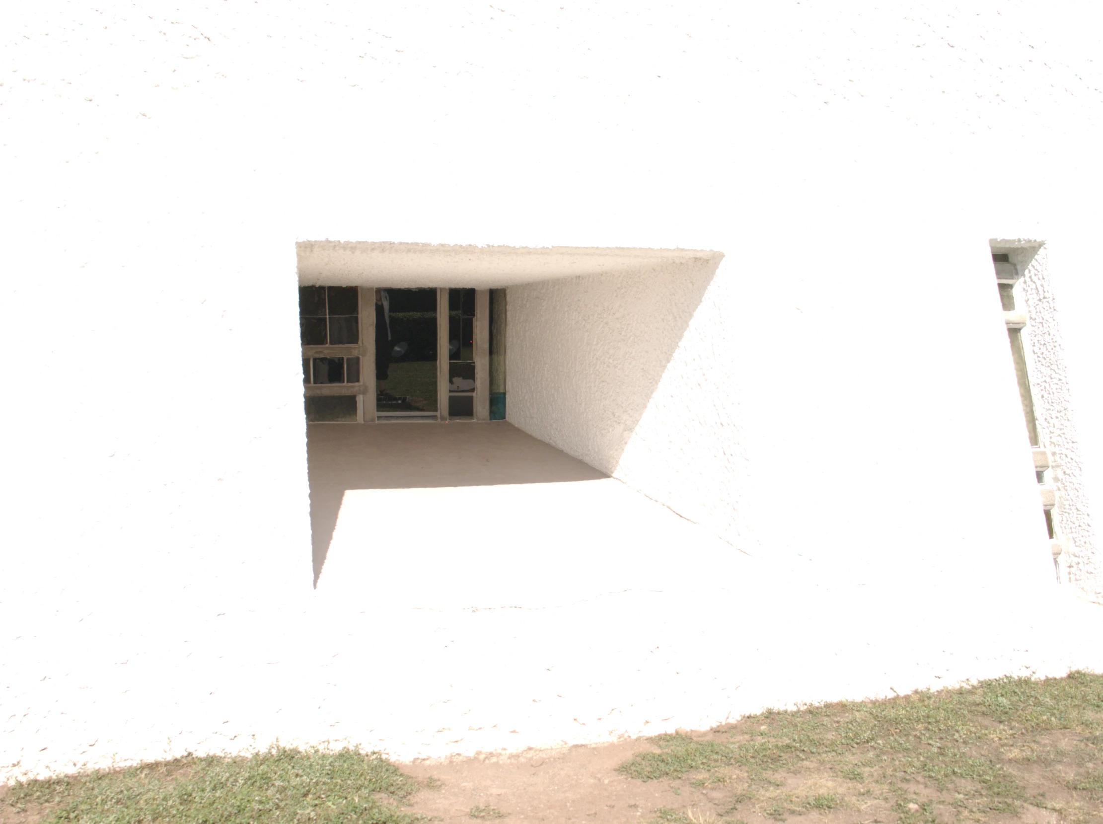 a window in a white building with a red fire hydrant