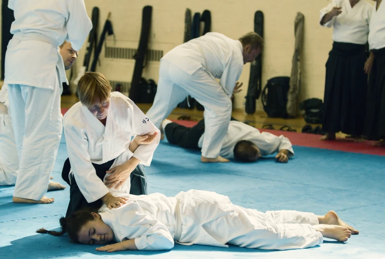 two female students wrestle on the ground with one another