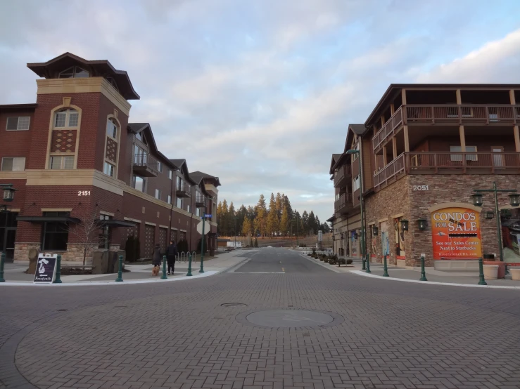 an empty street surrounded by brick buildings with a stone sidewalk