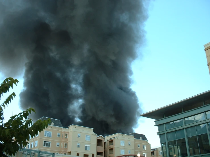 a cloud of black smoke in the air near a building