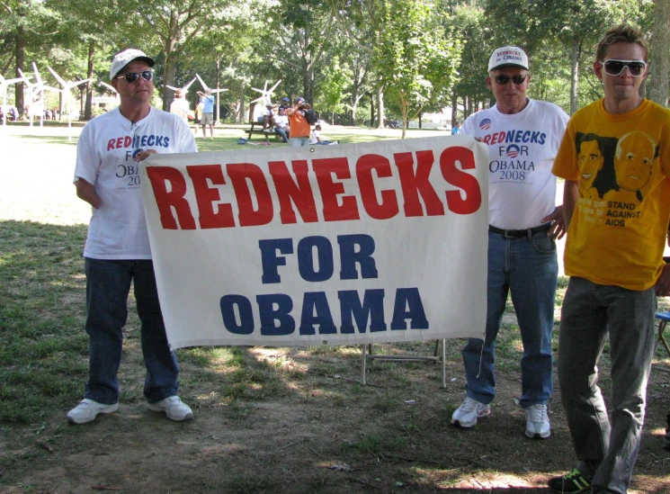 a group of three young men holding a sign for rednecks for obama