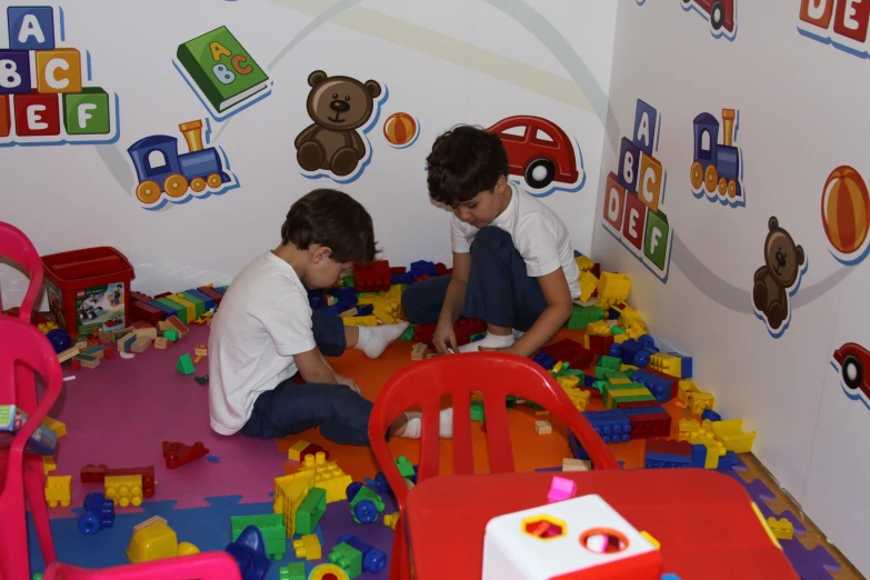 two children play with building blocks and toys