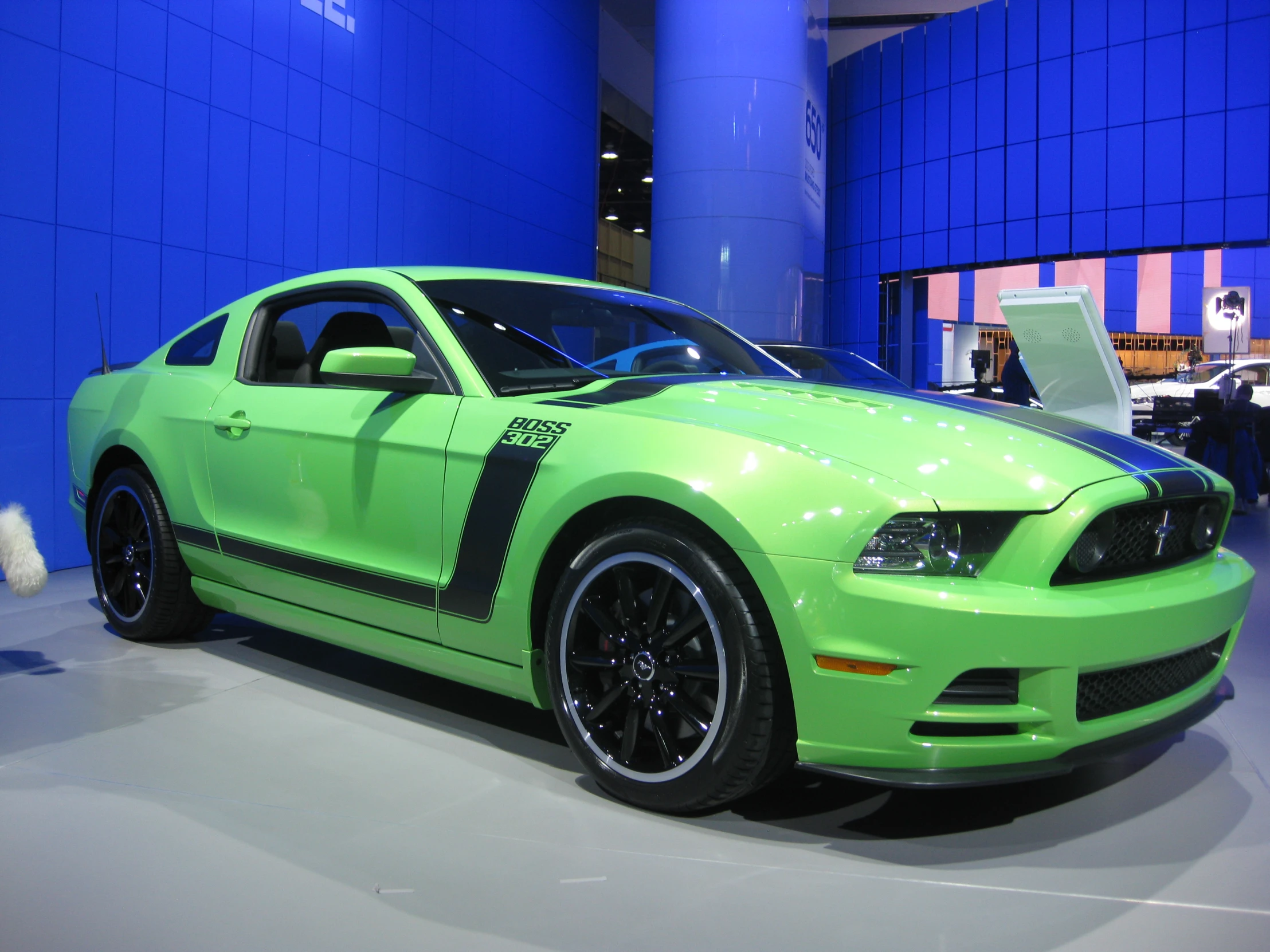 the front end of a green mustang car in a show room