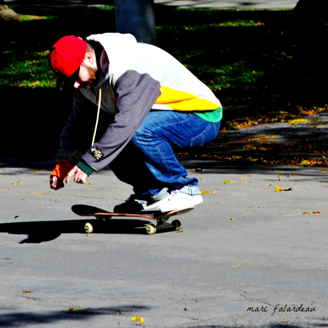 a man crouches down while riding his skateboard
