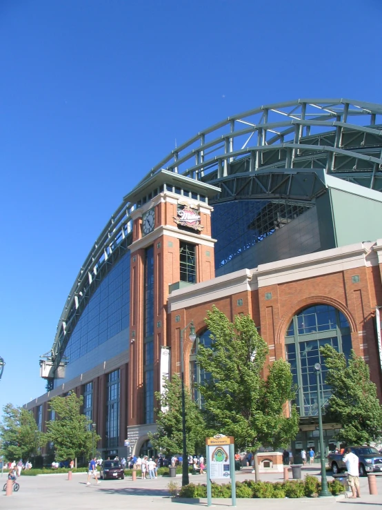 a large brick stadium with many people walking by