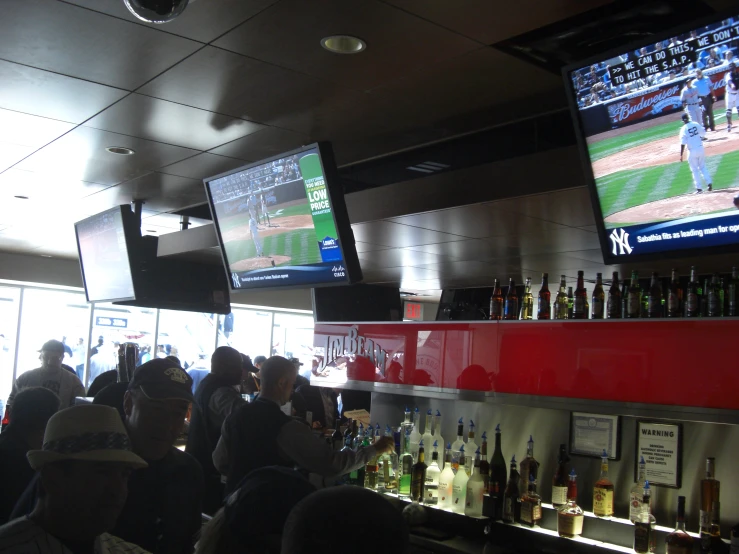 a group of people watch baseball on a large screen