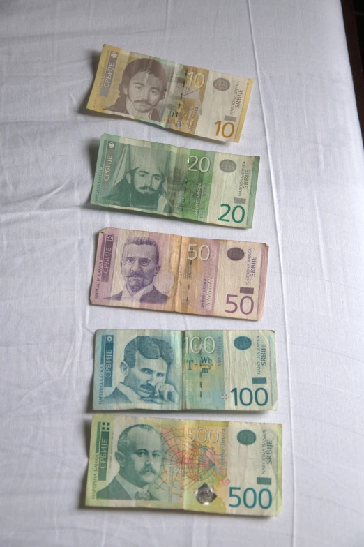 a row of five different bills laying on a table
