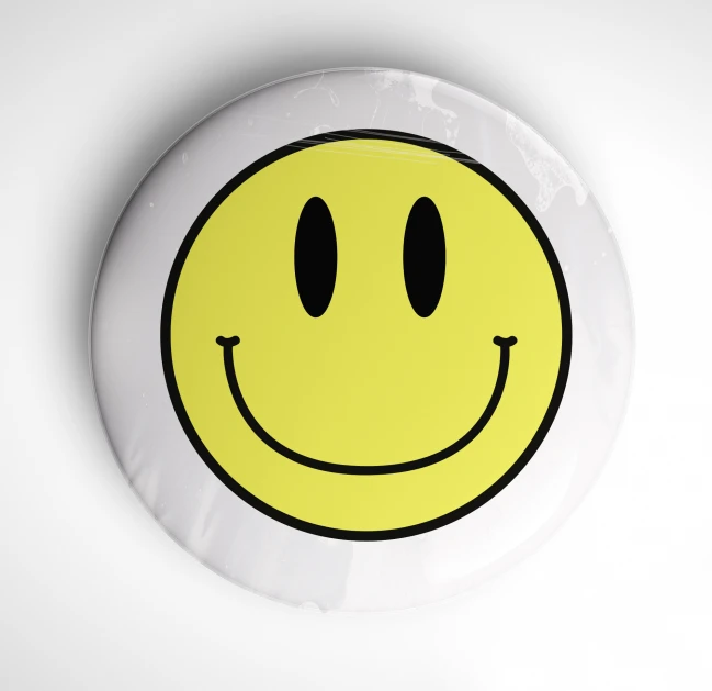 yellow smiley face shaped frisbee on white background