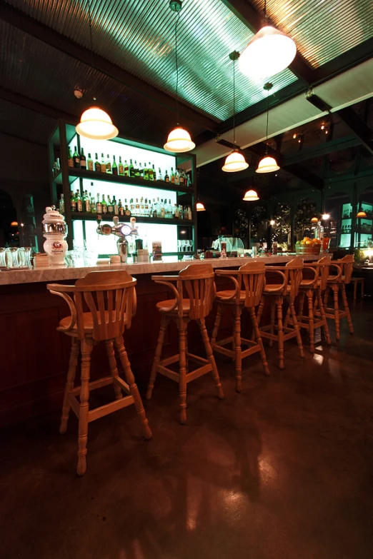 a bar filled with wooden chairs sitting next to a counter