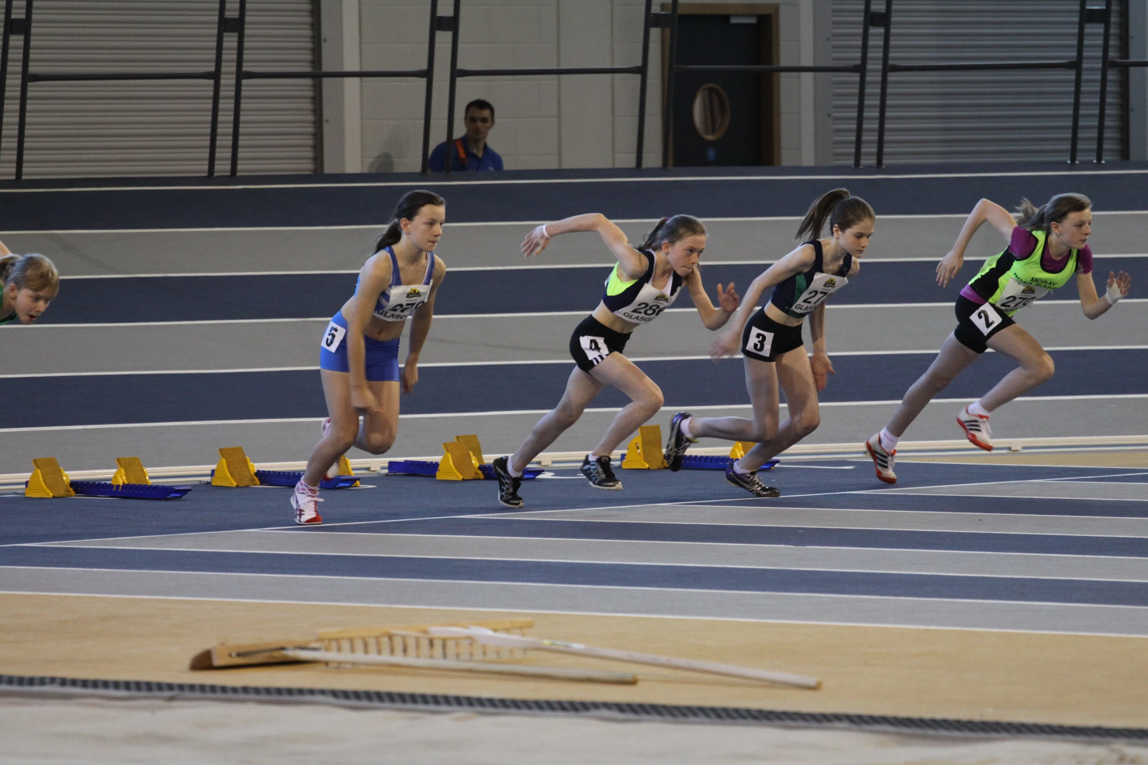 a line of women are running around a track