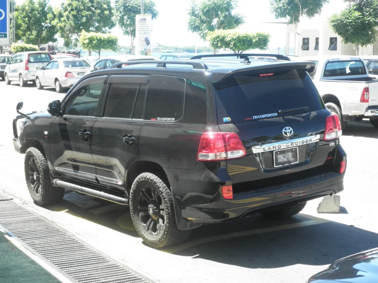 an suv is parked in front of several other cars
