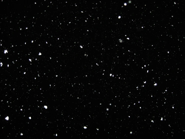 a dark sky with lots of white dots on the surface