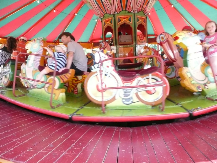 people riding on the merry go round with carousels in the background