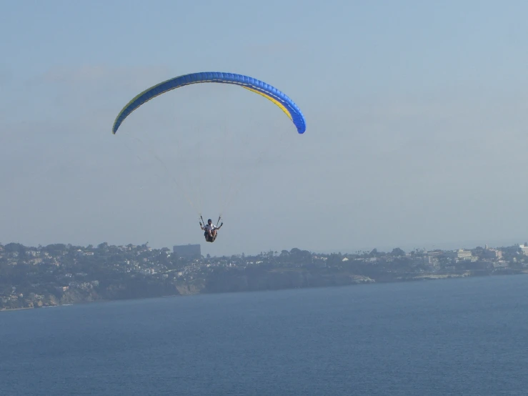 parasailer soaring through the air in front of some buildings