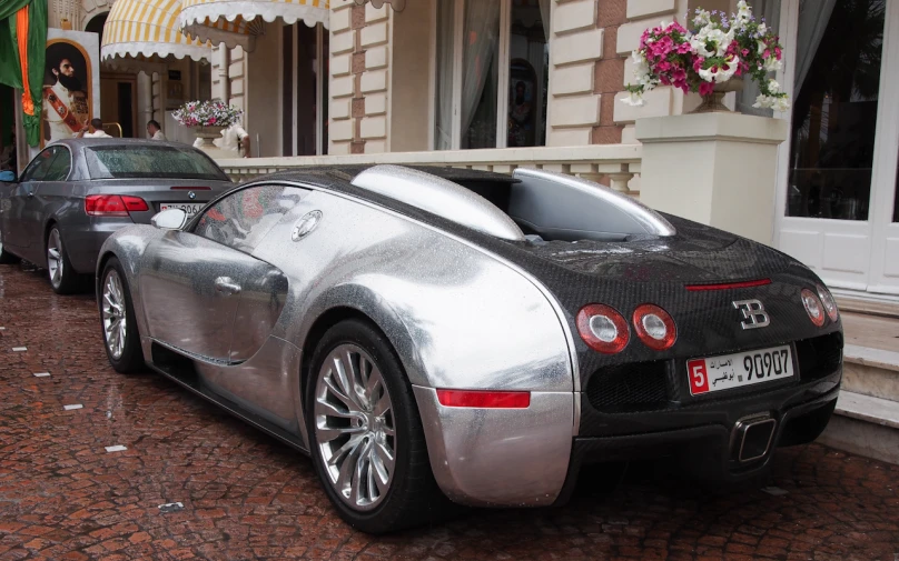 the silver sports car is parked in front of the building