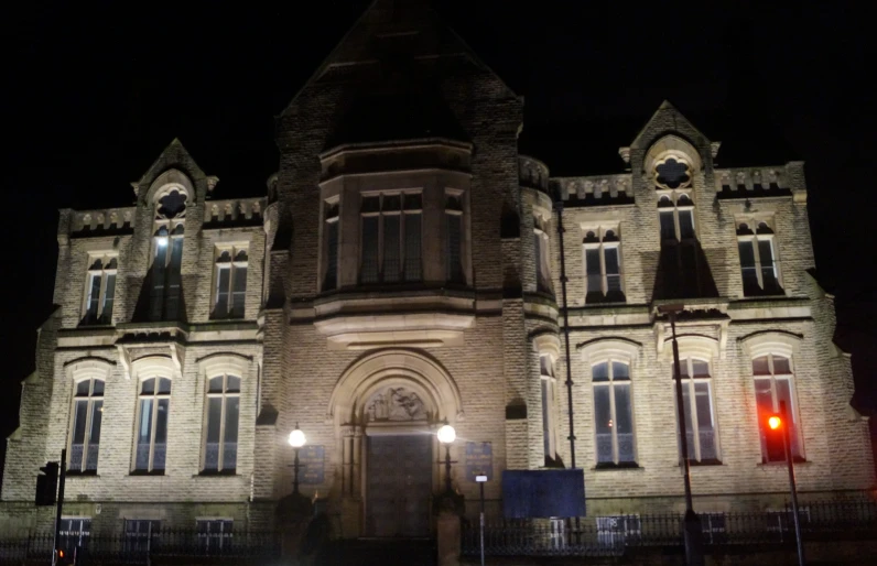 an old building lit up at night with lots of windows