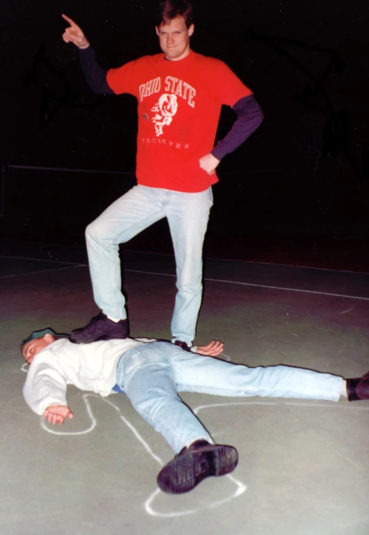 two men, one on the ground and one on the ground, both skateboarding