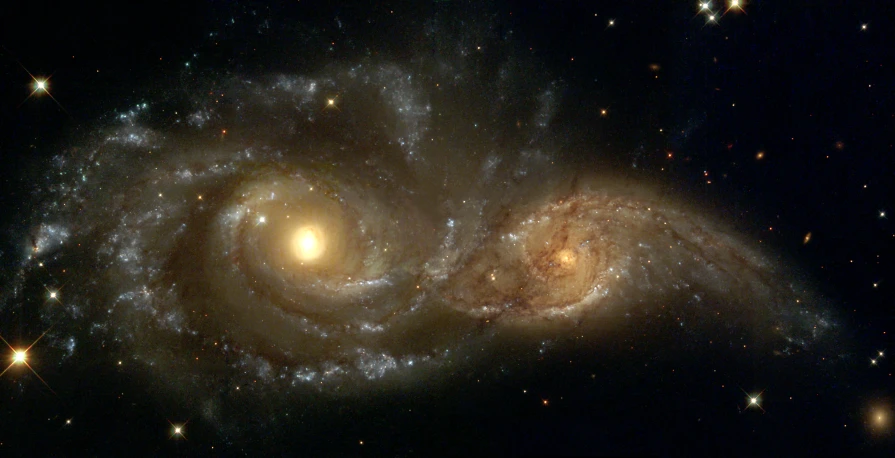two spirally shaped objects are shown in the night sky
