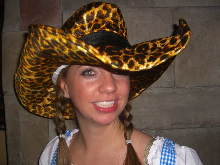 a young woman wearing a cowgirl hat and blue plaid dress