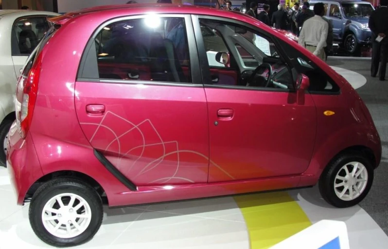 a pink car that is parked in the street