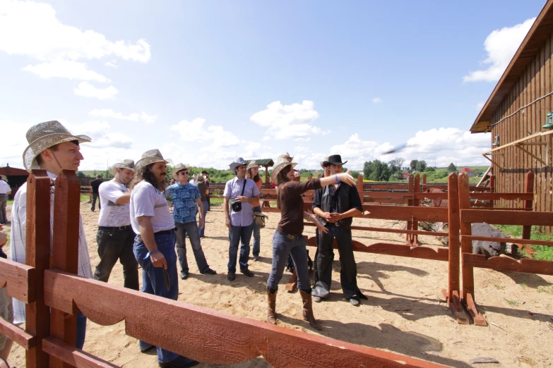 a group of people in front of a brown and white horse