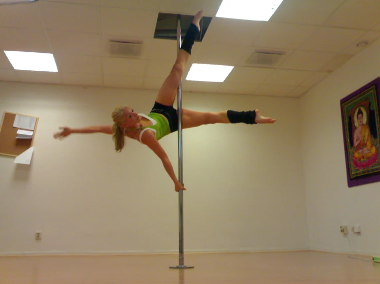 a woman leaning on a pole and performing tricks