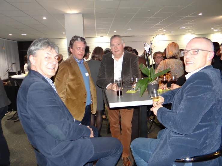 a group of men wearing blue suit standing around a table