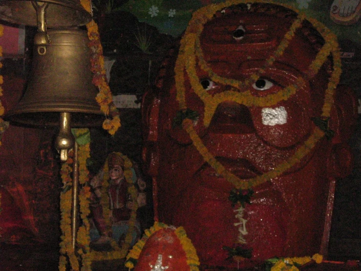 a decorated statue with a bell next to it